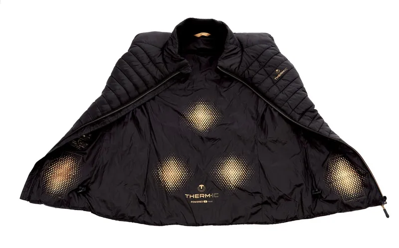 Geöffnete Therm-ic Heated Vest. Blick auf Innenseite mit Heizelementen an Bauch, Taschen, Nieren und Rücken. Schwarz und Gold.