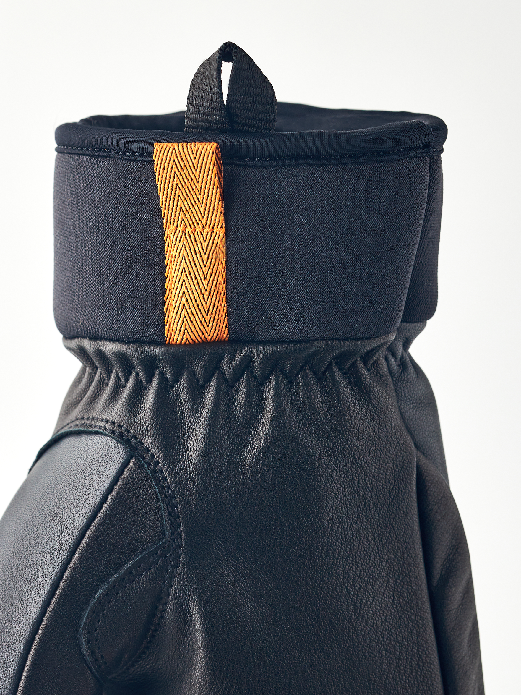 Nahaufnahme vom Hestra Army Leather Wool Terry Fäustling mit Lederteil und Band.