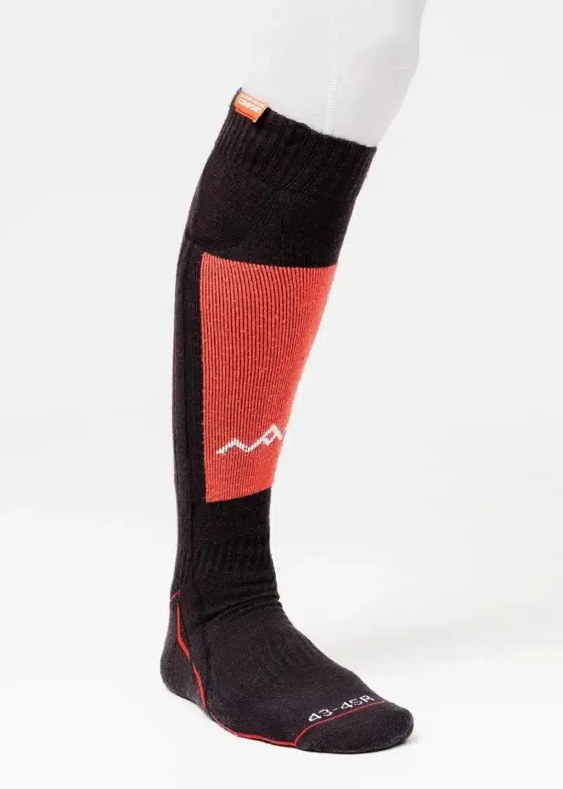 Ein Bein mit einer schwarzen, langen Socke. Die Socke hat eine orangefarbene Partie mit einem weißen Bergsymbol.