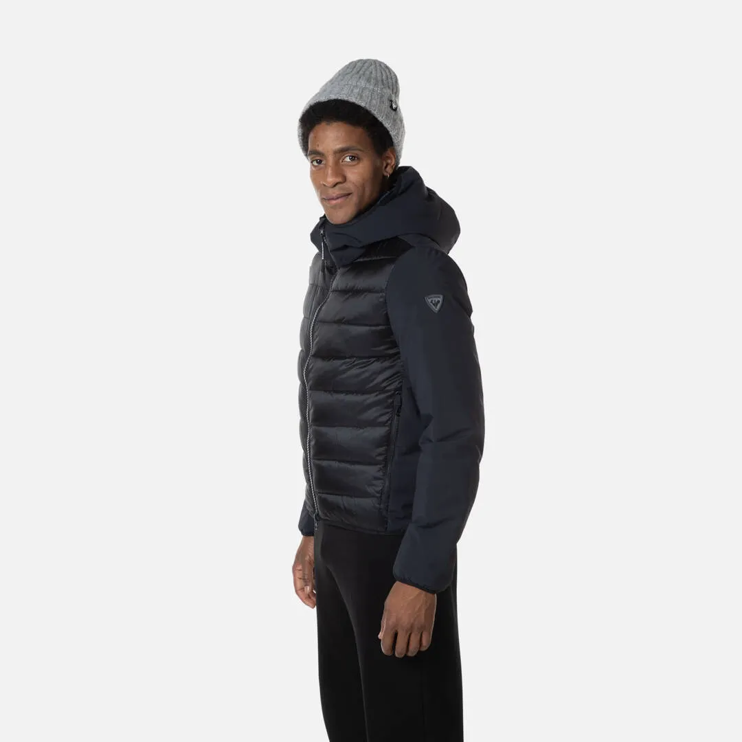 Mann mit Mütze trägt Rossignol Stretch Quilt Hoodie JKT in Schwarz, Seitenansicht.