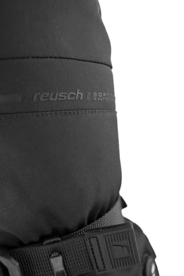 Nahaufnahme des Reusch Advanced Heat R-TEX XT Mitten mit Logo und Gurt. Schwarzes, wasserabweisendes Material.