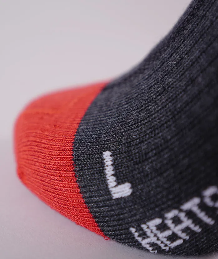 Detailaufnahme einer grauen Socke mit roter Spitze, einer weißen "L"-Kennzeichnung und dem Wort "HEAT".