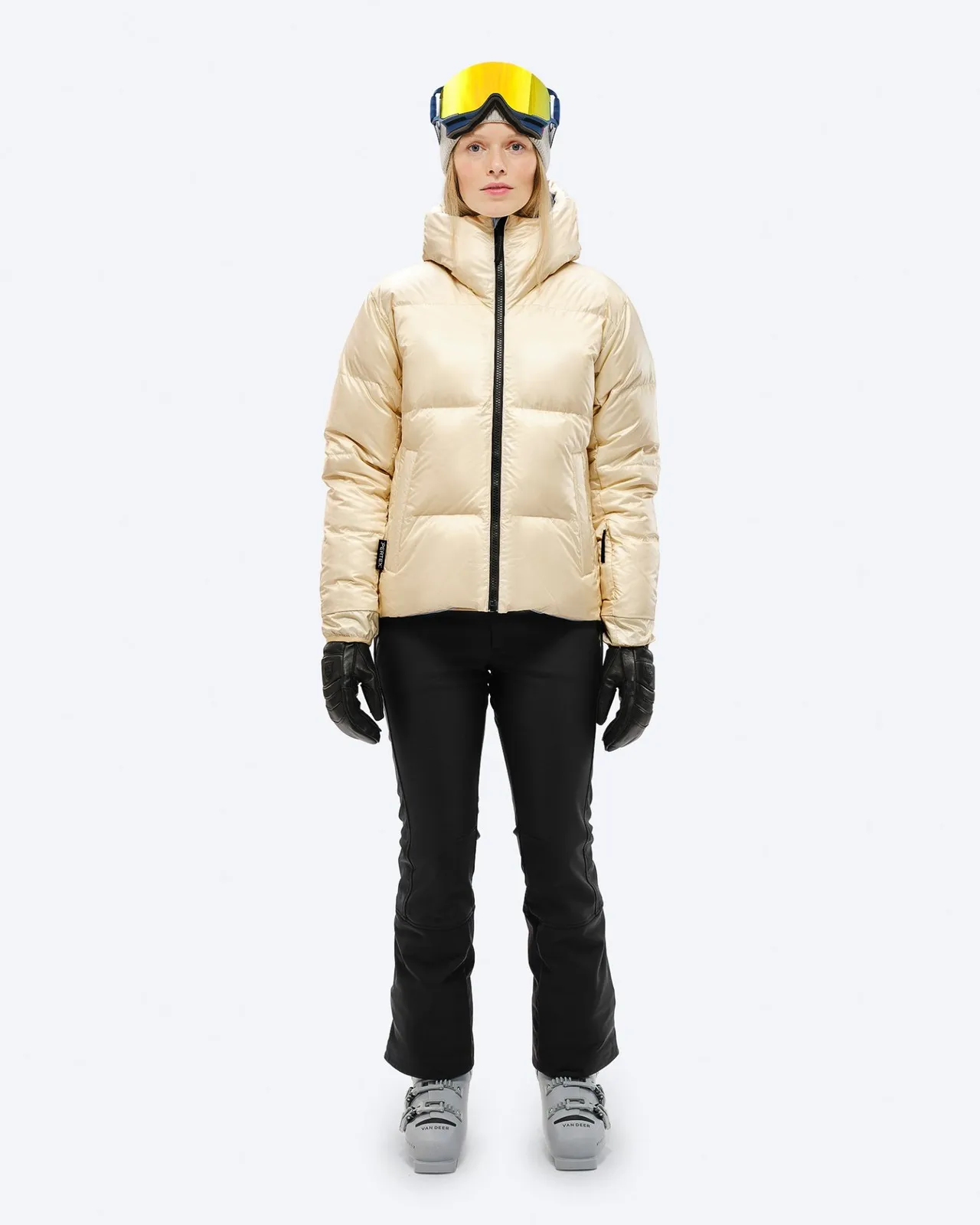 Person in Daunenjacke, Skihose, Skischuhe und Skibrille, Frontansicht, "Castle Wall" Farbe.