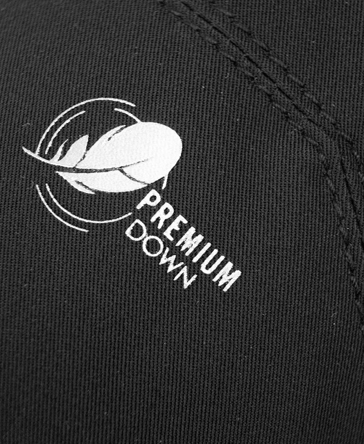 Premium Down-Logo Detail Detailaufnahme: "Premium Down"-Logo mit stilisierter Feder auf schwarzem Reusch Volcano Pro GTX Mitten Material.