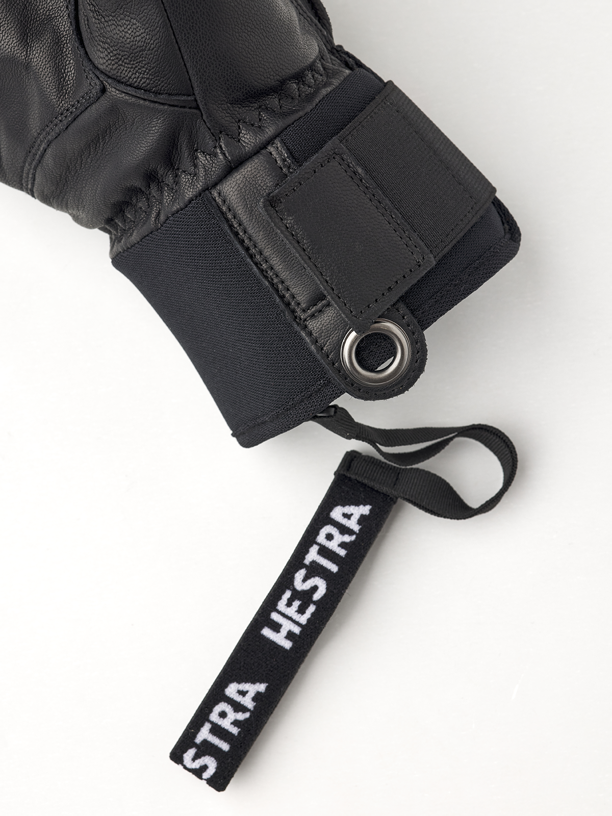 Detailaufnahme eines schwarzen Hestra Fall Line Skihandschuhs mit Markenanhänger.