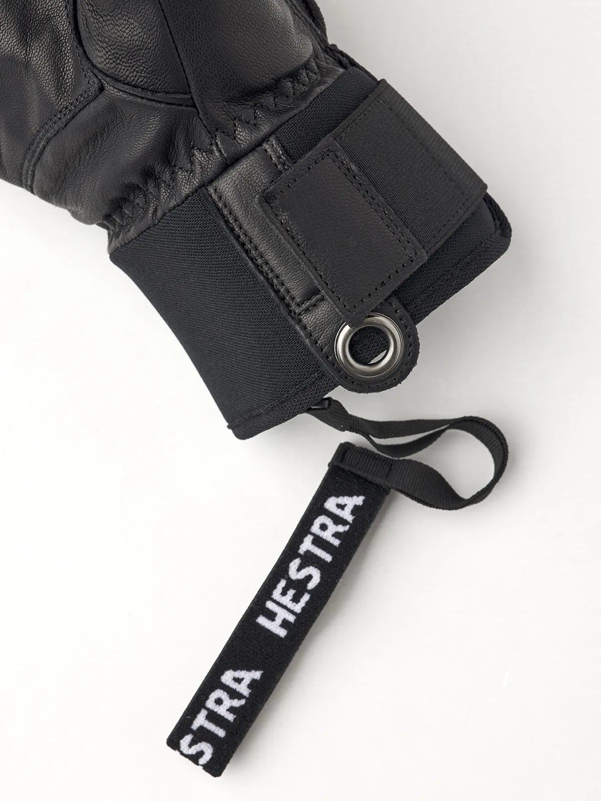 Detailaufnahme eines schwarzen Hestra Fall Line Skihandschuhs mit Markenanhänger.
