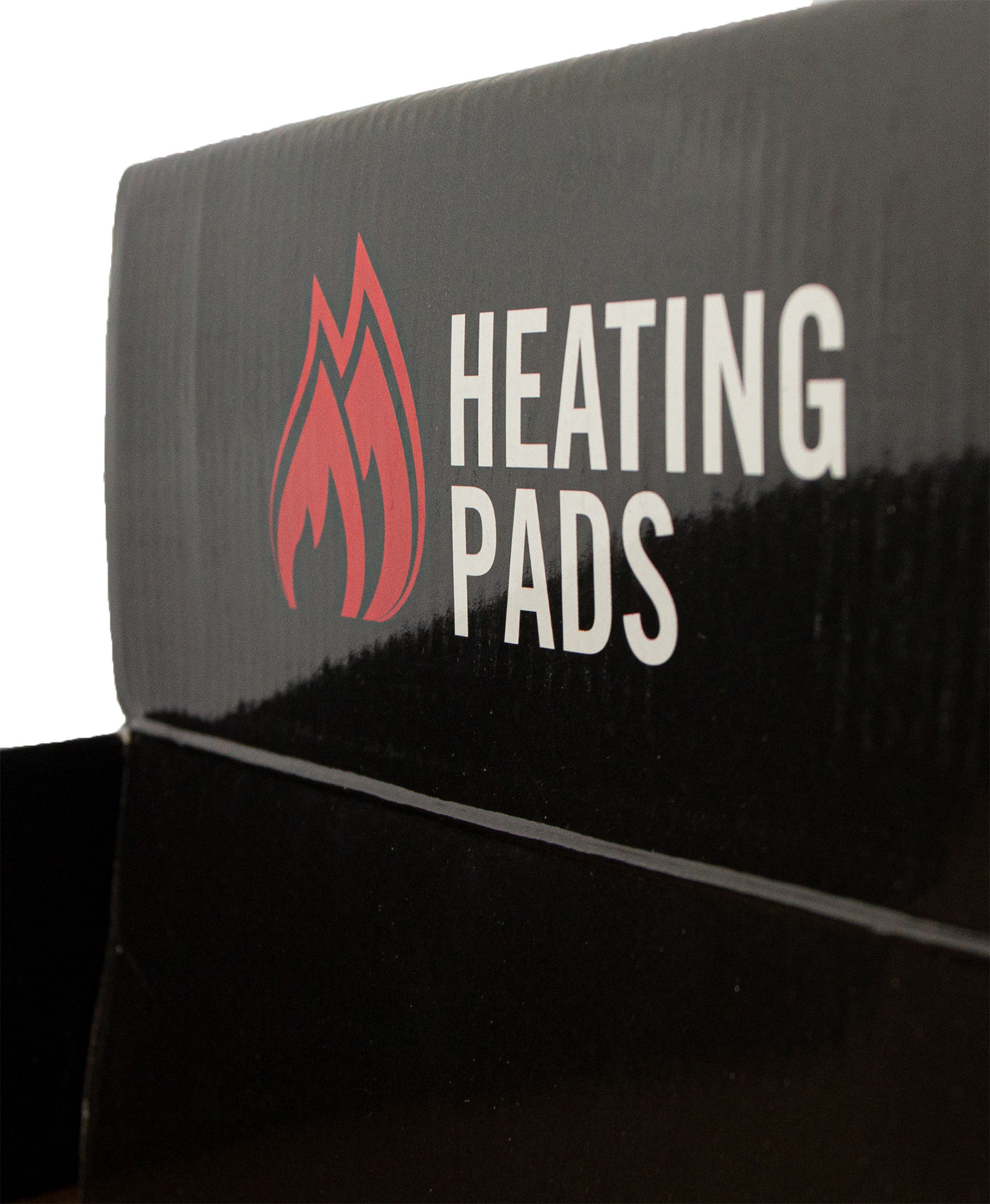 Schwarze Kartonverpackung, Aufschrift "HEATING PADS" in Weiß, daneben rotes Flammensymbol.