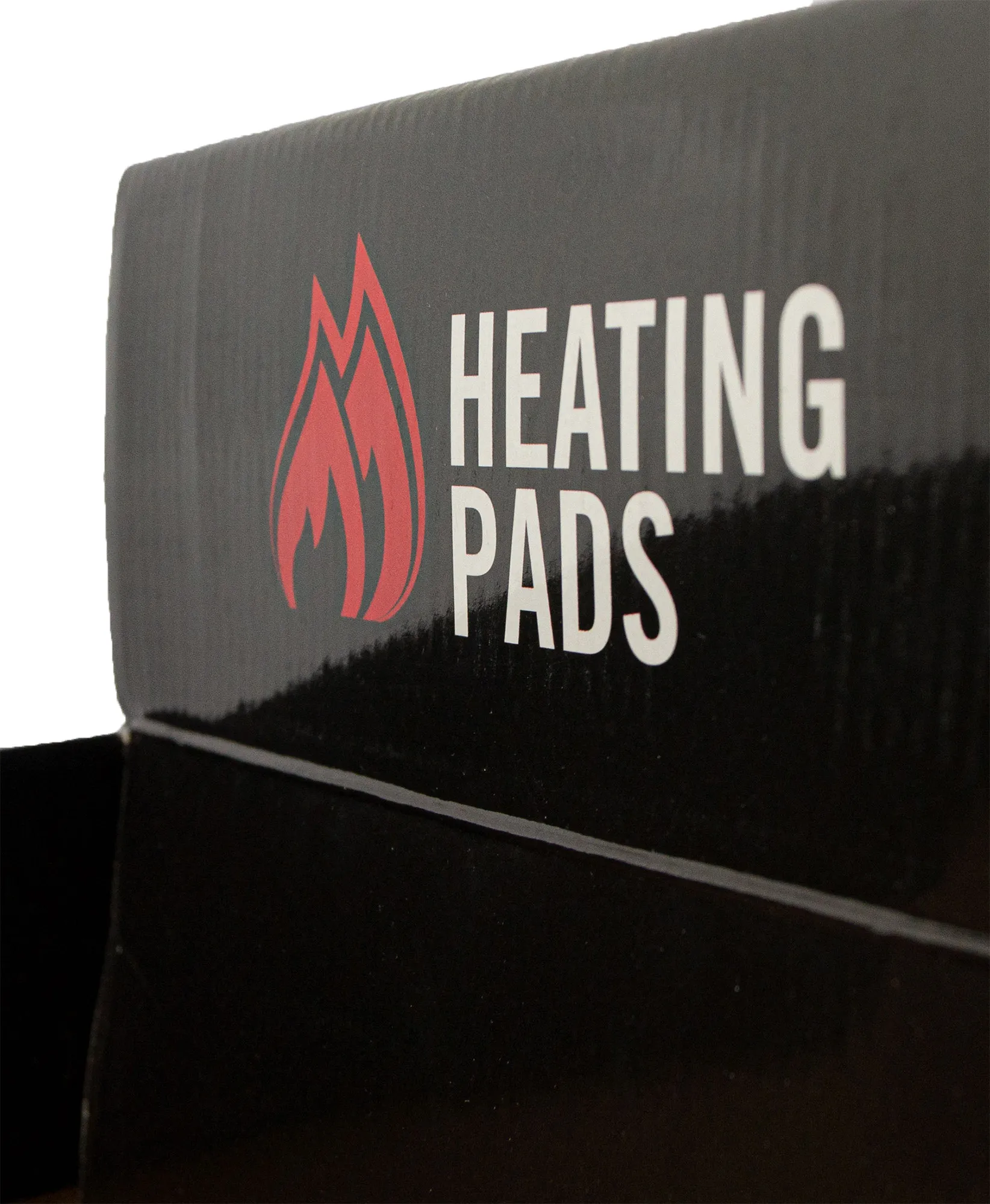 Schwarze Kartonverpackung, Aufschrift "HEATING PADS" in Weiß, daneben rotes Flammensymbol.