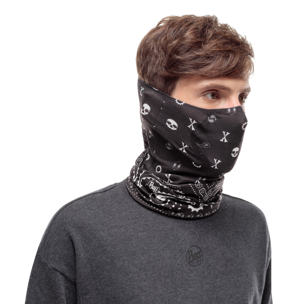 Mann trägt einen schwarzen Buff Filter Tube mit Totenkopfmuster und grauem Shirt.
