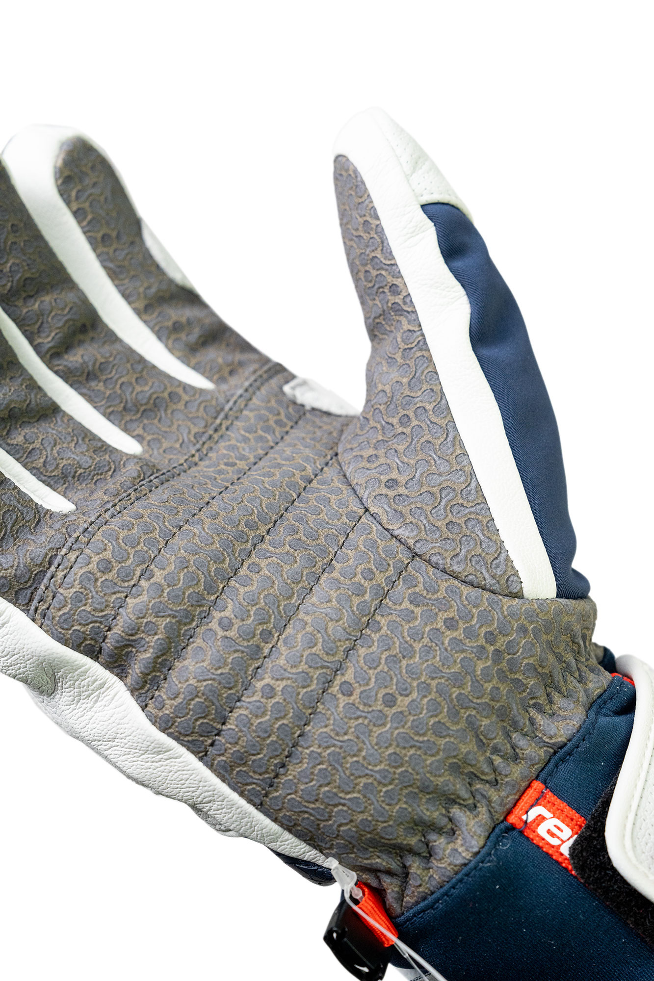 Grauer Handschuh mit Streifen Nahaufnahme eines Handschuhs mit grauer Handfläche, weißen Streifen an den Fingern und marineblauem Gewebe.