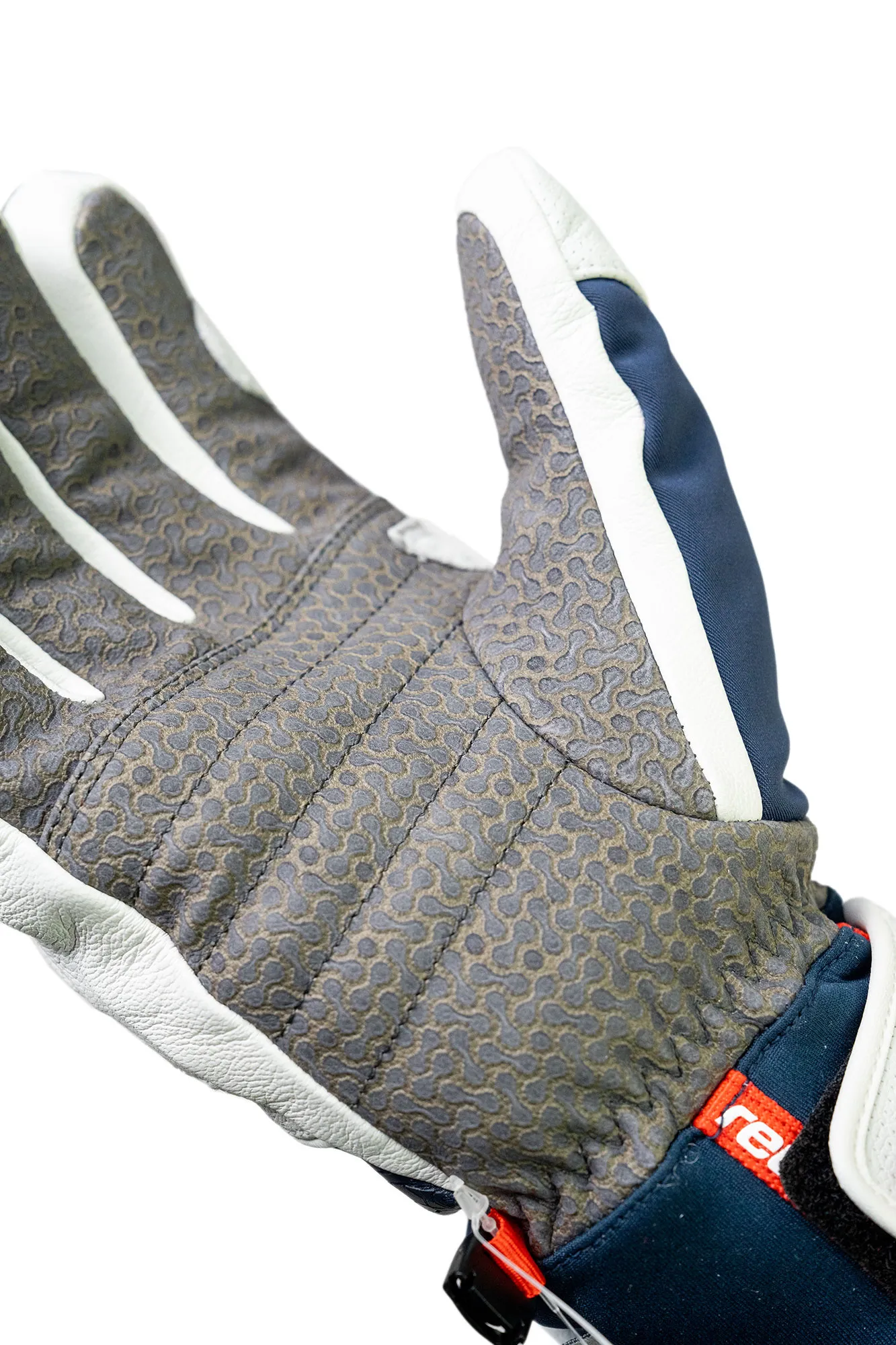 Nahaufnahme eines Handschuhs mit grauer Handfläche, weißen Streifen an den Fingern und marineblauem Gewebe.