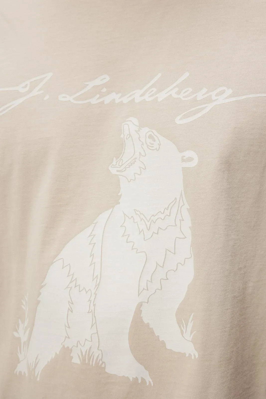 Detailaufnahme eines T-Shirts in Oyster Gray, bedruckt mit einem Bären und dem Schriftzug "J. Lindeberg".