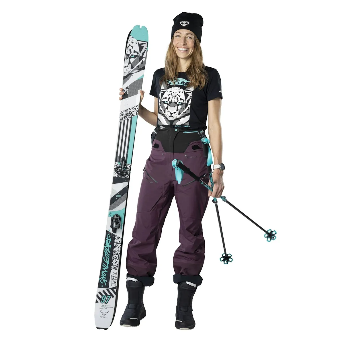 Frau mit Ski-Ausrüstung: Ski, Hose, Stöcke. Ski mit Aufdruck.