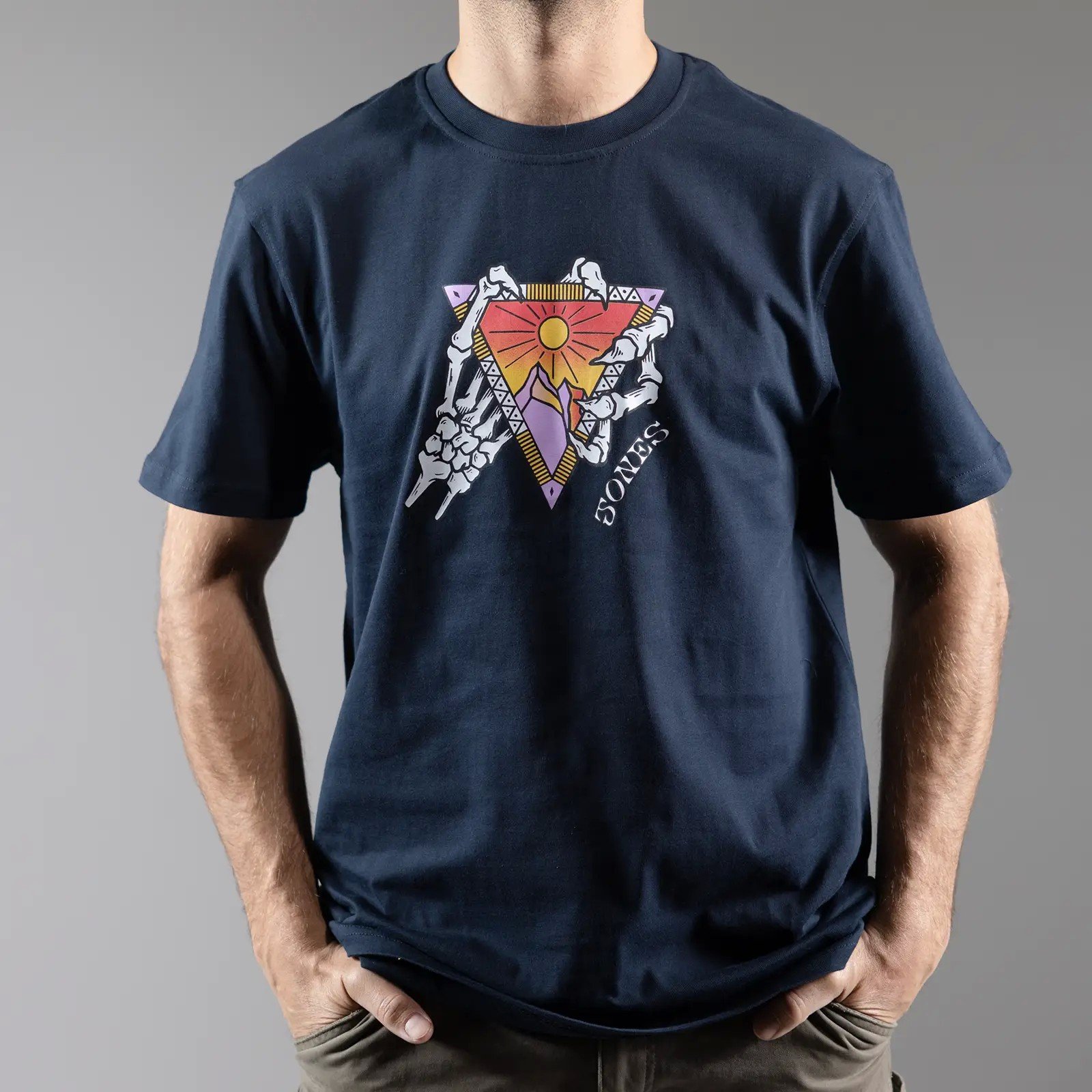 Navy Jones Organic Cotton Tee mit Berg, Sonne und Skelett Hände Grafik Design.
