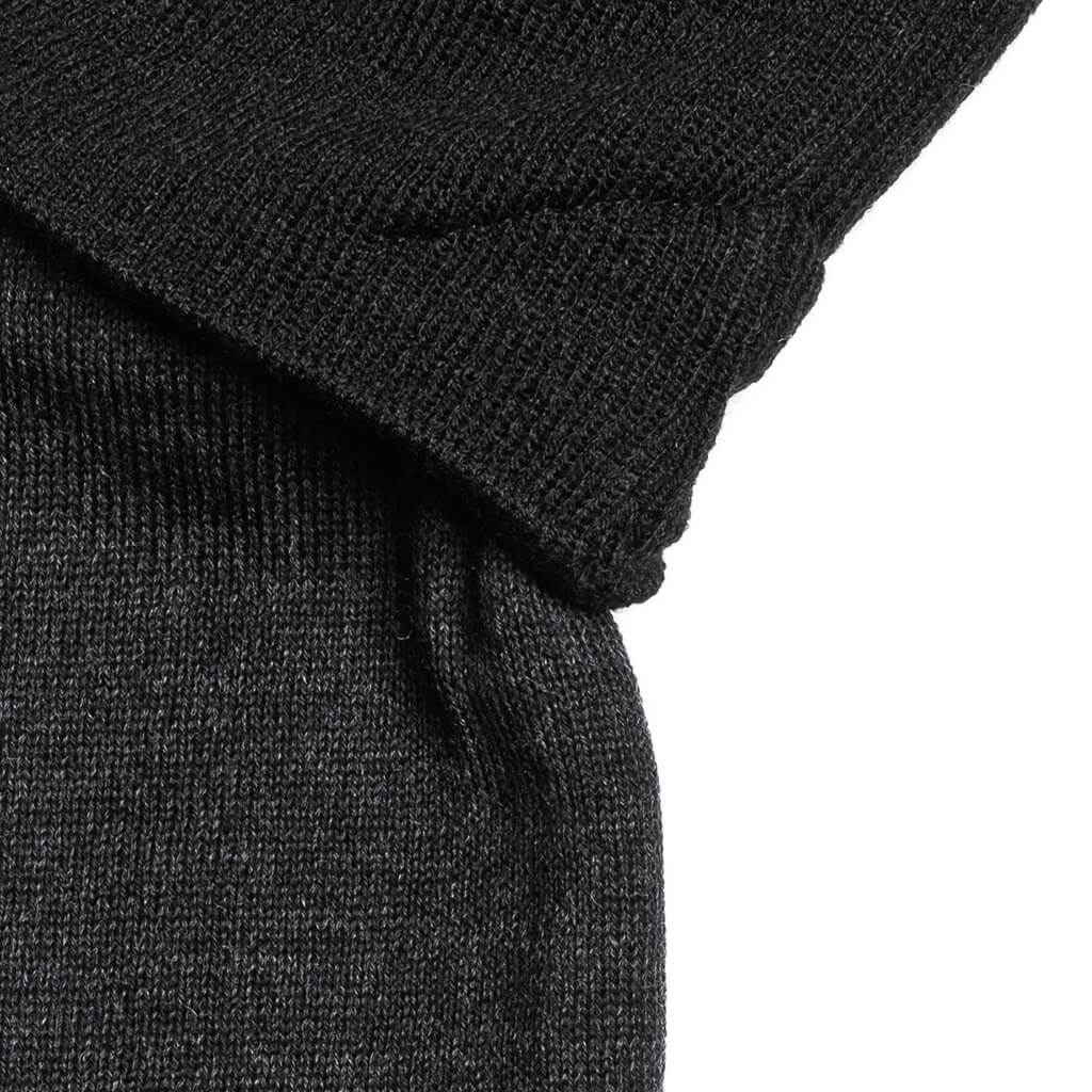 Schwarzes Beanie-Set Detailaufnahme des schwarzen "The JB" Beanie- und Neckwarmer-Sets. Strickmuster erkennbar.