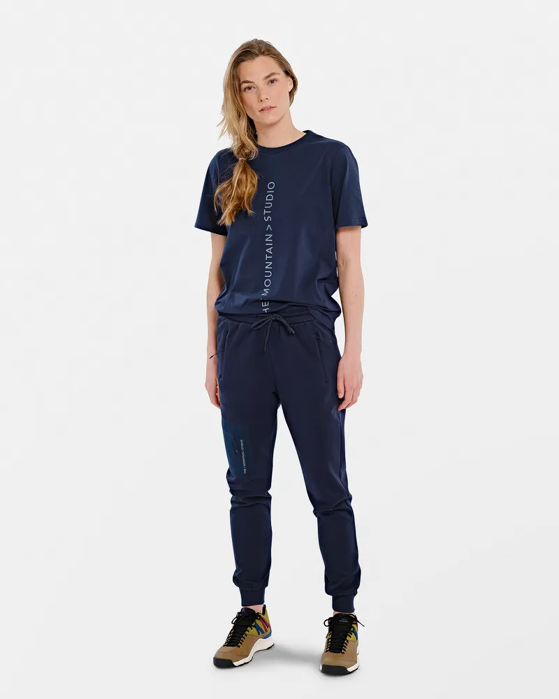 Person in marineblauem T-Shirt mit vertikalem Logo und passender Hose.