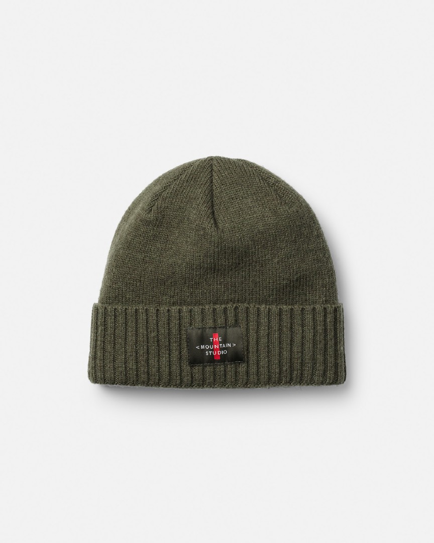 Grüne Cashmere Mix Beanie mit geripptem Rand und kleinem, schwarzem Logo-Patch mittig auf dem Umschlag.