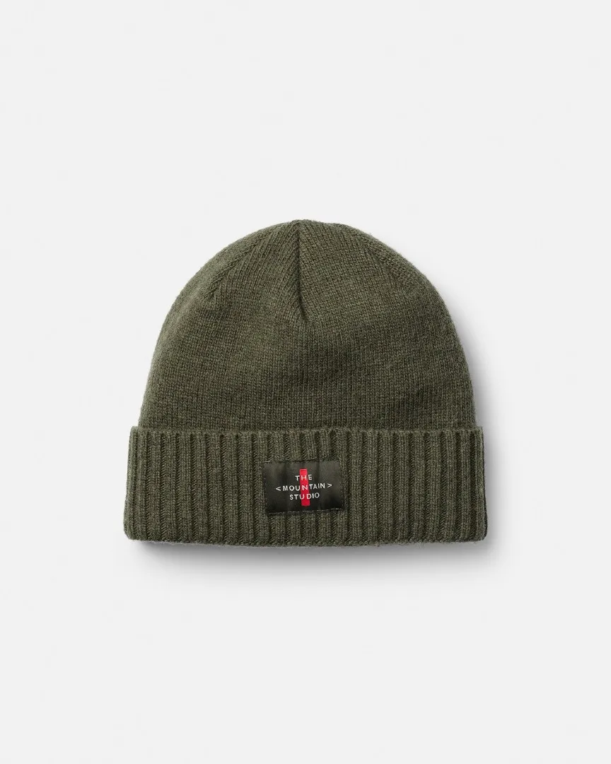Grüne Cashmere Mix Beanie mit geripptem Rand und kleinem, schwarzem Logo-Patch mittig auf dem Umschlag.