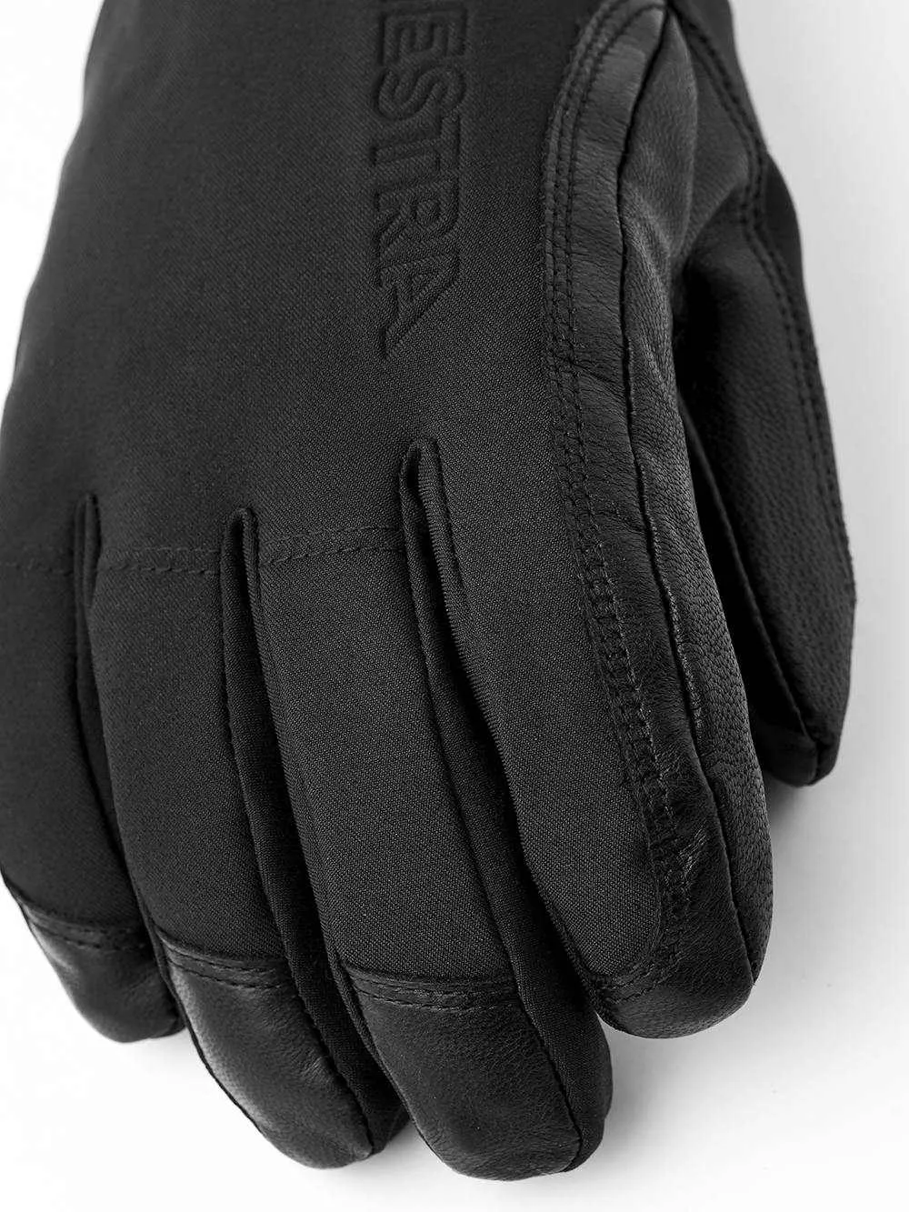 Detailansicht eines schwarzen HESTRA-Handschuhs, der Leder und Textil kombiniert, mit Fokus auf Textur und Verarbeitung.