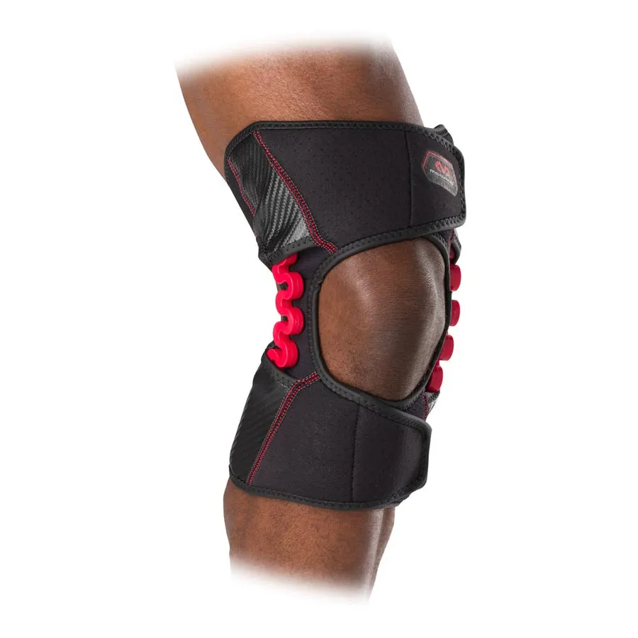Nahaufnahme: Kniebandage McDavid NRG Knee Over Wrap 30590 mit rotem Gelenk und schwarzem Stoff am Bein einer Person.