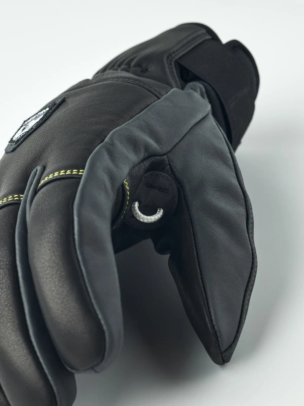 Nahaufnahme eines schwarzen Leder Hestra Omni Trigger Handschuhs mit Schlaufe, Fokus auf Finger.