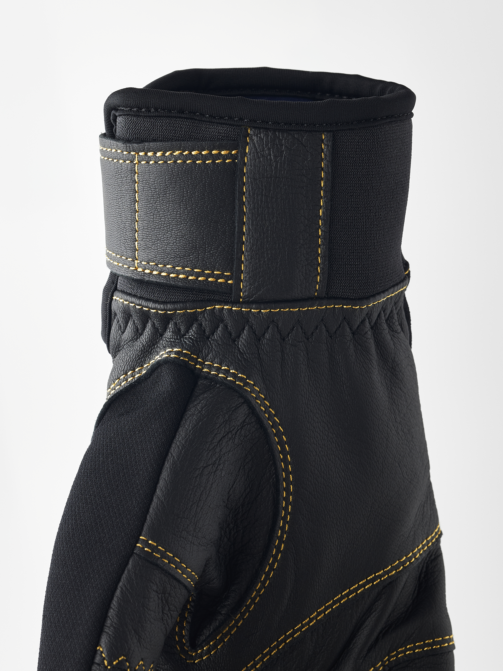 Schwarze Hestra Handschuhe Nahaufnahme eines schwarzen Hestra Ergo Grip Active Handschuhs mit gelben Nähten.