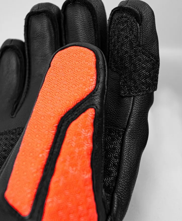 Detailaufnahme eines schwarzen Reusch Worldcup Warrior SC Handschuhs mit orangenem Aufdruck.