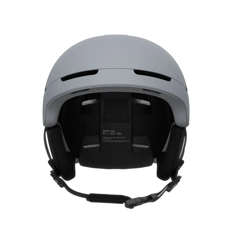 Grauer Skihelm von vorne, mit Belüftungsöffnungen, Ohrenschützern und verstellbarem Kinnriemen. Innen Mesh-Polsterung.