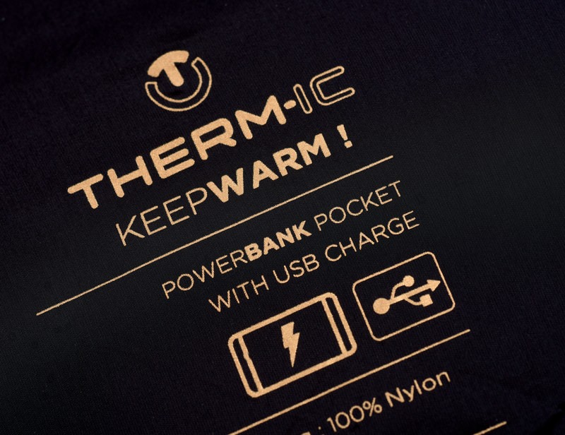 Therm-ic Heizweste Damen Detailaufnahme der Therm-ic Heated Vest Women mit Markenlogo und Aufdruck: "KEEPWARM! Powerbank Pocket with USB Charge."