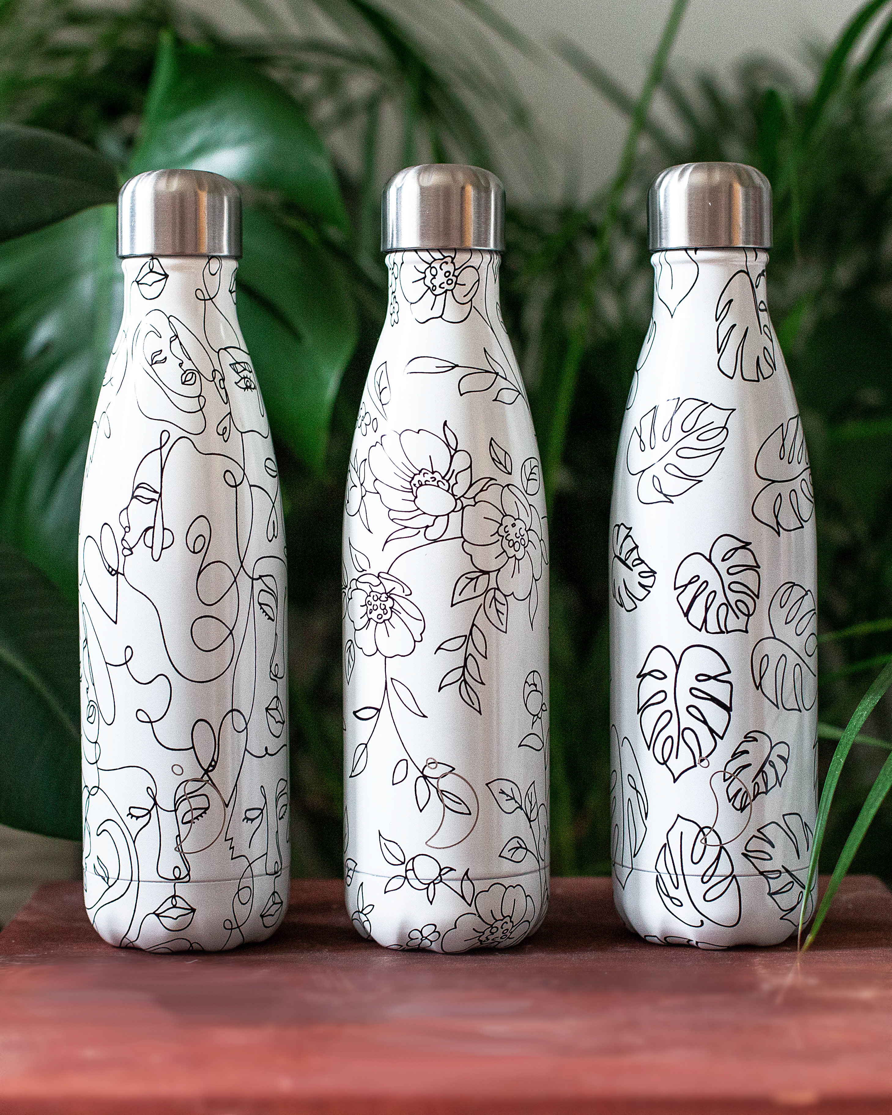 Linienkunst Trinkflaschen Drei Chillys Trinkflaschen mit Line-Art: Gesichter, Blumen und Blätter.