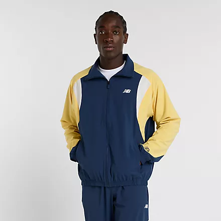 Mann in marineblauer/gelber New Balance In Game Track Jacket mit Reißverschluss.